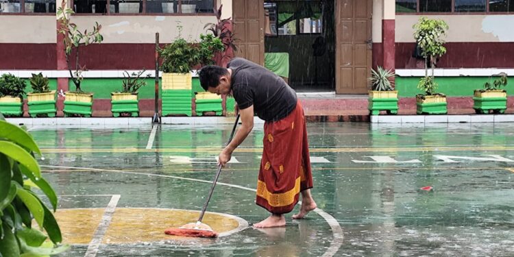 ‎Aksi Heroik Kepala Sekolah di Pinrang: Rela Basah Kuyup Demi Halaman Bersih dan Aman Siswa